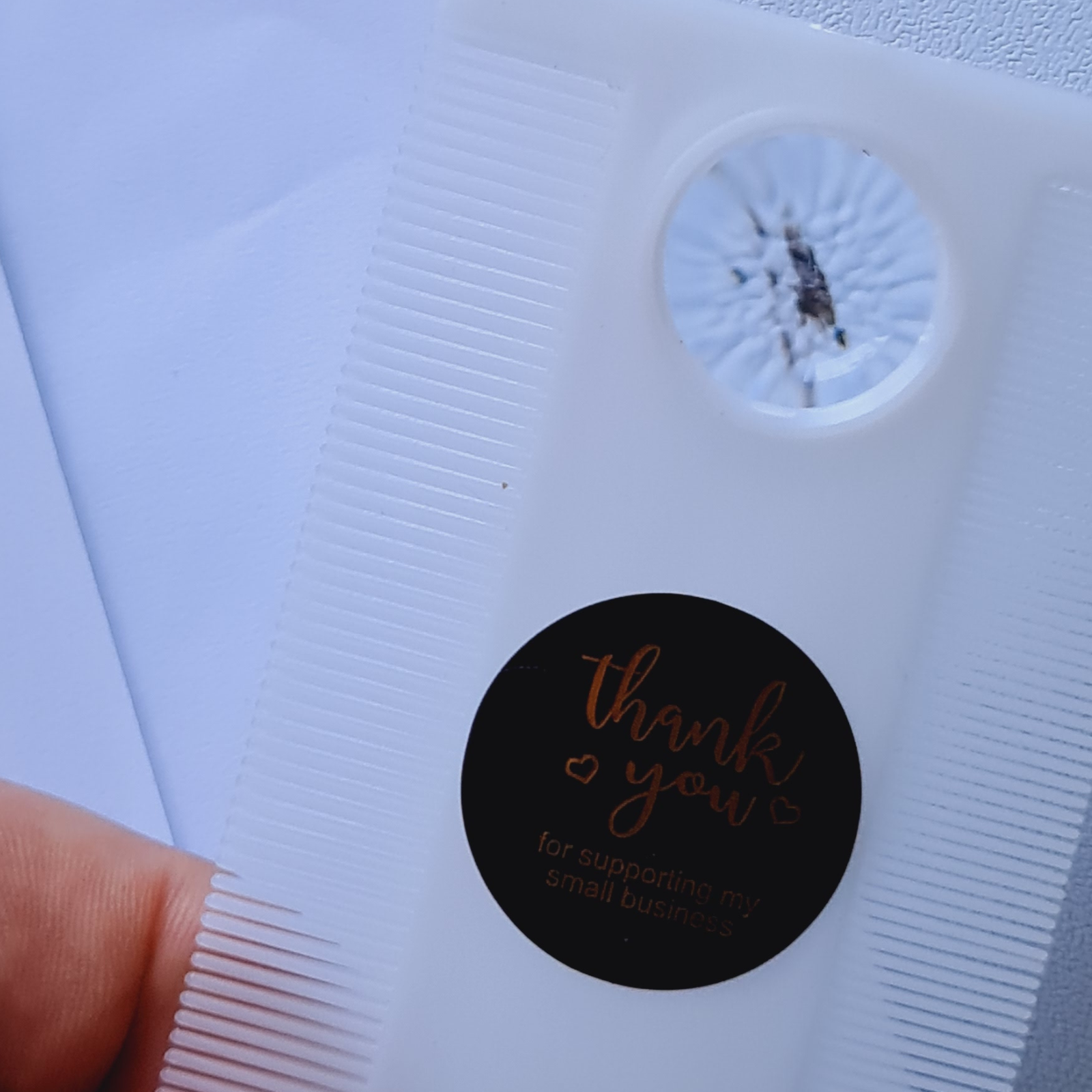 Black round sticker with 'thank you' text on a white background