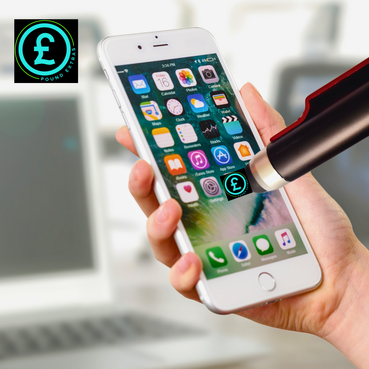 Hand holding a smartphone with app icons, blurred background with laptop and pen.