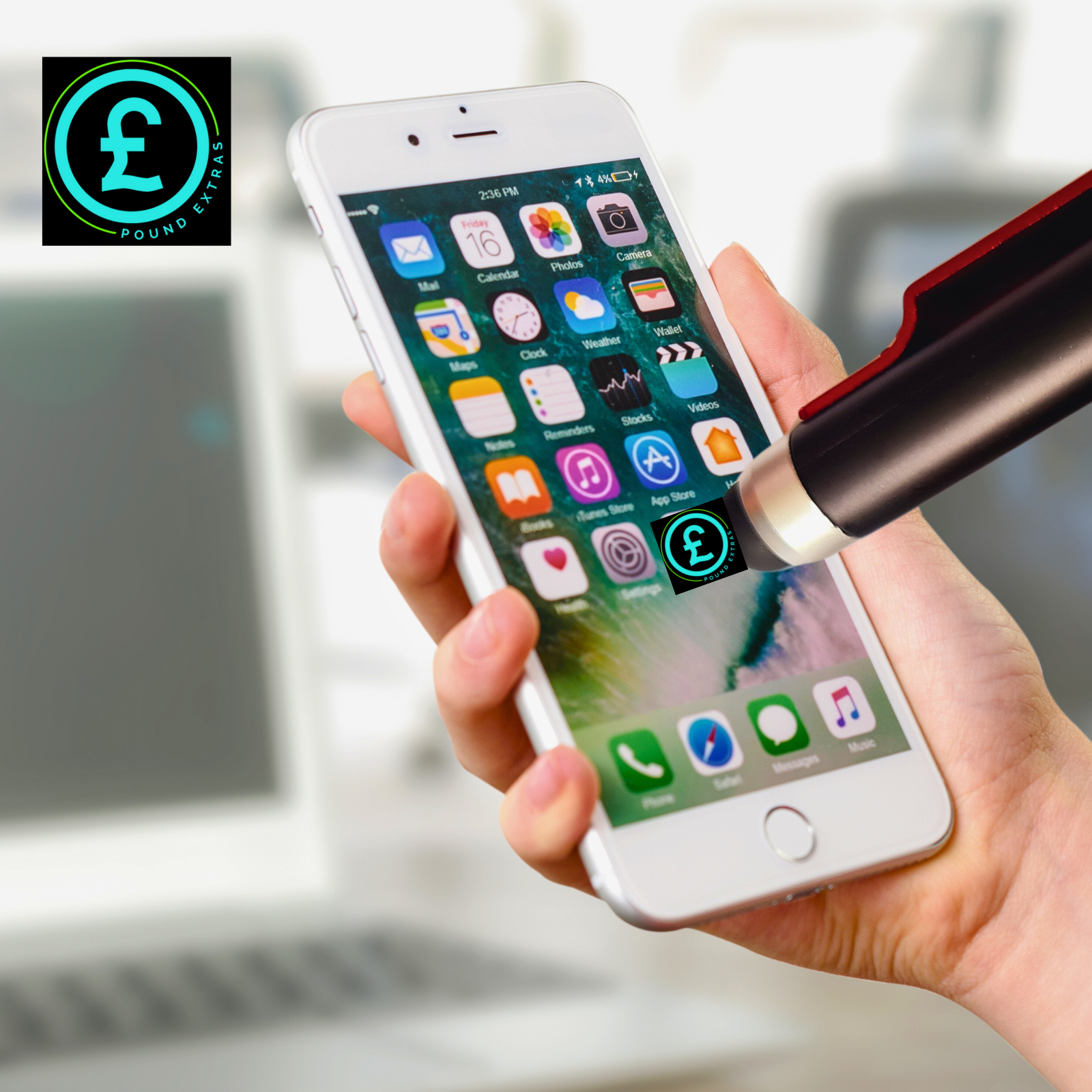 Hand holding a smartphone with app icons, blurred background with laptop and pen.